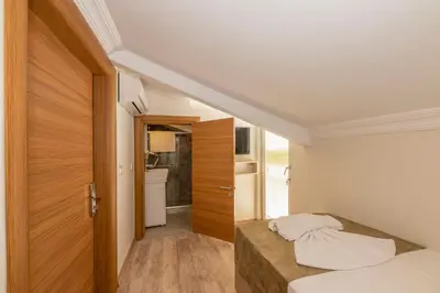 a small bedroom with a bed and a wooden door at Bazaar Hotels Old City in Istanbul