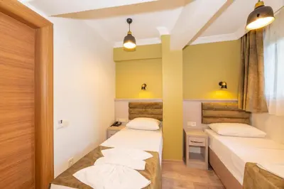 two beds in a room with yellow walls at Bazaar Hotels Old City in Istanbul