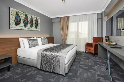 a hotel room with a bed and a desk at Luxon Hotel Sakarya in Sakarya
