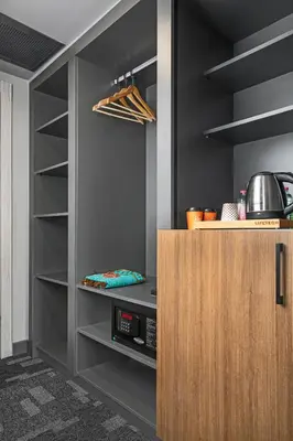 a kitchen with a pantry with a wooden cabinet at Luxon Hotel Sakarya in Sakarya