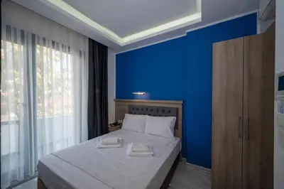 a blue bedroom with a bed with two towels on it at Okda Hotel in Istanbul