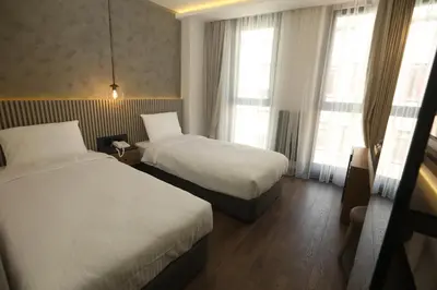 a hotel room with two beds and two windows at Moja City Hotel in Istanbul