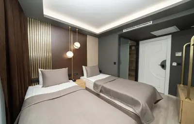 a bedroom with two beds and a mirror at Fama Karaköy in Istanbul