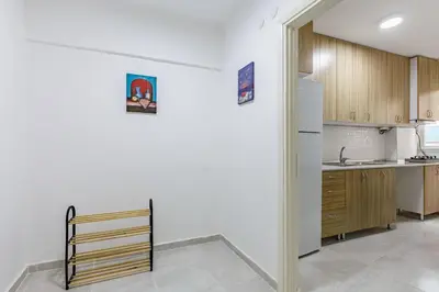 a kitchen with white walls and wooden cabinets at Altiyol Boga, Center of Kadıköy in Istanbul