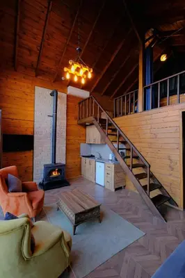 a living room with a staircase and a fireplace at Woodlodge Country Sapanca in Sapanca