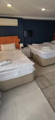 two beds in a bedroom with a blue wall at Laluna Hotel Near Grand Bazaar City Center in Istanbul