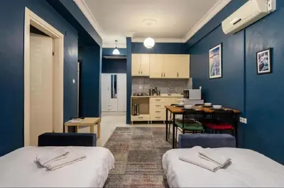 a blue room with two beds and a kitchen at Laluna Hotel Near Grand Bazaar City Center in Istanbul