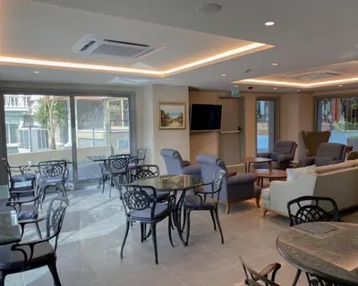 a waiting room with tables and chairs and a tv at Eresin Hotels Express in Istanbul