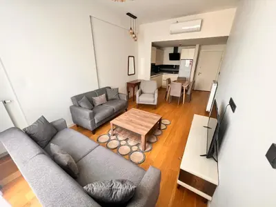 a living room with a couch and a table at G Tower Residence at Divan Near To Mimar Sinan Metro Station in Istanbul