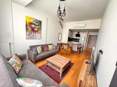 a living room with a couch and a table at G Tower Residence at Divan Near To Mimar Sinan Metro Station in Istanbul