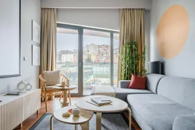 a living room with a couch and a large window at Benesta Residence by NewInn in Istanbul