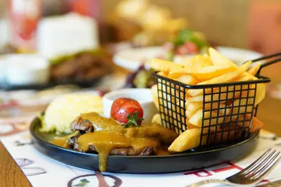 a plate of food on a table with french fries at King City Hotel Istanbul Ataturk Airport in Istanbul