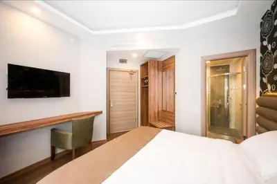 a bedroom with a bed and a desk and a television at King City Hotel Istanbul Ataturk Airport in Istanbul