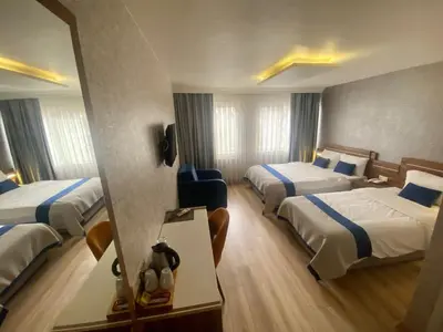 a hotel room with three beds and a mirror at ERA PALACE HOTEL B BLOK in Istanbul