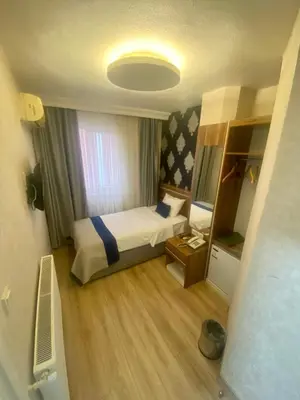 a small bedroom with a bed and a mirror at ERA PALACE HOTEL B BLOK in Istanbul