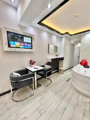 a bathroom with a tub and a table and a sink at Taksim Larissa hotel suites in Istanbul