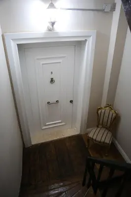 a hallway with a white door and a chair at Agus Flats Galata in Istanbul