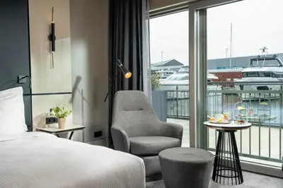 a hotel room with a bed and a chair and a balcony at Crowne Plaza Istanbul Tuzla Viaport Marina by IHG in Istanbul