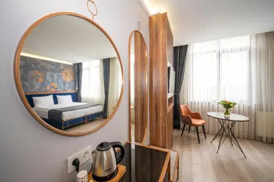 a room with a mirror and a bed and a table at Seyithan Palace Spa Hotel in Istanbul