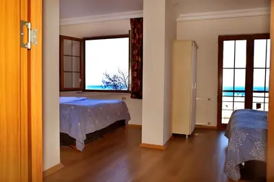 a room with two beds and two windows at Miletus Otel Şile in Sile