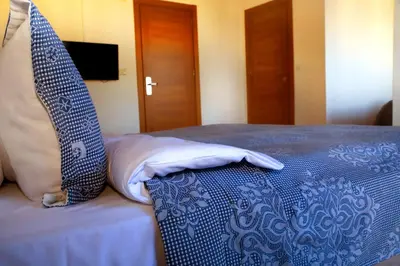 a bed with a blue and white comforter and pillows at Miletus Otel Şile in Sile