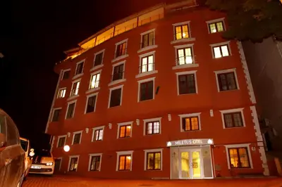 a large red building with its lights on at Miletus Otel Şile in Sile