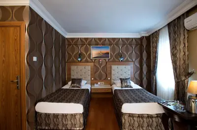 a hotel room with two beds and a wall at Şirin Hotel in Istanbul