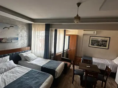 a hotel room with two beds and a table at yakut old hotel in Istanbul