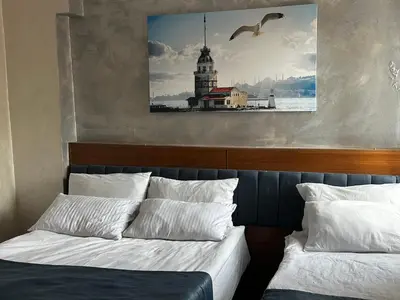 a bedroom with two beds and a picture of a lighthouse at yakut old hotel in Istanbul