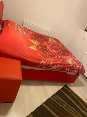 a red bed with a red blanket with a flower on it at SNOW HİLL HOUSE Pansiyon in Kartepe