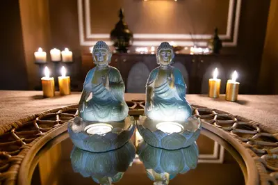 two statues sitting in front of a mirror with candles at Vela Verde Hotel & SPA in Yalova