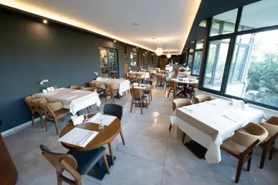 a restaurant with tables and chairs and windows at Vela Verde Hotel & SPA in Yalova