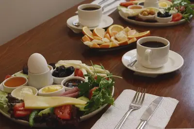 a wooden table with plates of food and cups of coffee at White Palace Old City Boutique Hotel in Istanbul