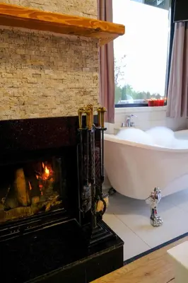 a bathroom with a fireplace and a tub and a sink at World DREAMS Sapanca in Sakarya