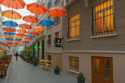 a row of orange umbrellas hanging from a building at Taksim Istiklal Street Kamilbey Hotel in Istanbul