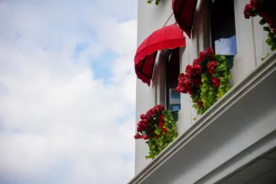 a window with flowers and a red umbrella at İzz Hotel Koşuyolu in Istanbul