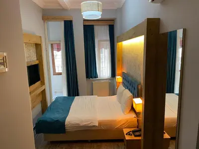 a small bedroom with a bed and two windows at Miss City Hotel Taksim in Istanbul
