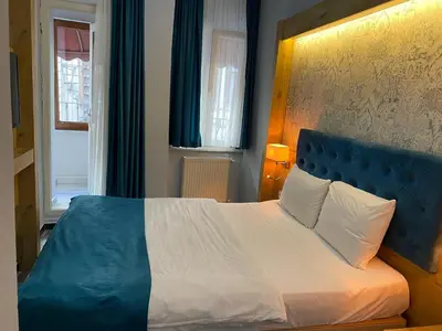 a bedroom with a large bed with a blue headboard at Miss City Hotel Taksim in Istanbul