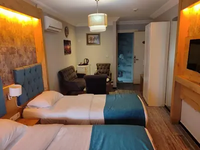 a hotel room with two beds and a living room at Miss City Hotel Taksim in Istanbul