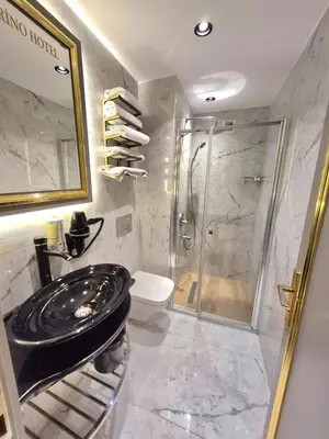 a bathroom with a shower and a black sink at Taksim La Marino Hotel in Istanbul