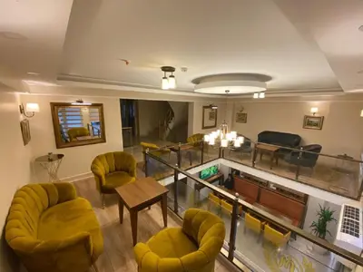 a living room with yellow chairs and a table at Hotel Mavirem in Istanbul