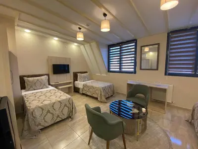 a bedroom with two beds and a table and chairs at Hotel Mavirem in Istanbul