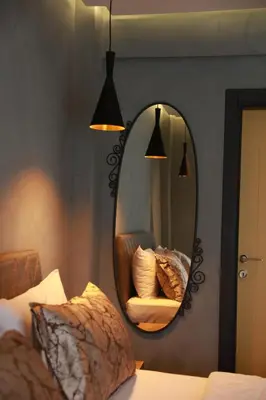 a mirror on a wall next to a bed at Adess Otel in Çekmeköy