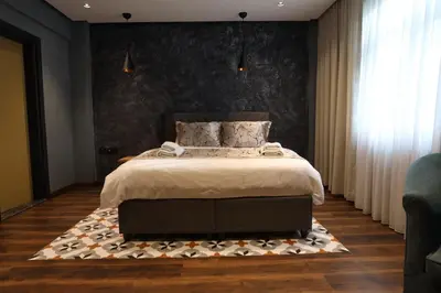 a bedroom with a bed with a black wall at Adess Otel in Çekmeköy