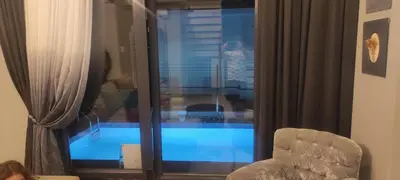 a room with a view of a swimming pool through a window at family villas 2 in Sapanca