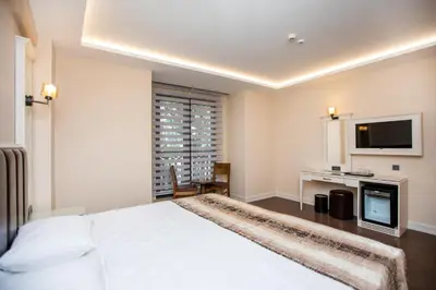 a bedroom with a white bed and a television at PRAG HOTEL in Istanbul