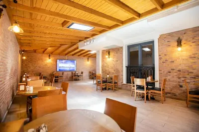 a restaurant with wooden ceilings and tables and chairs at Opatija Hotel in Istanbul