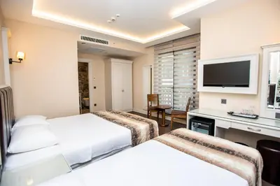 a hotel room with two beds and a desk at Opatija Hotel in Istanbul