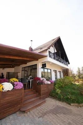 a building with a porch with flowers on it at Villa Nora Butik Otel ve Bungalov in Bursa