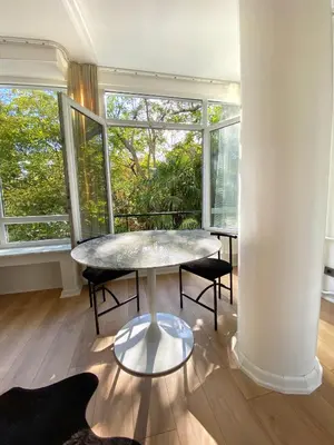 a table and chairs in a room with windows at Petek Pansiyon Fenerbahce Kadikoy in Istanbul